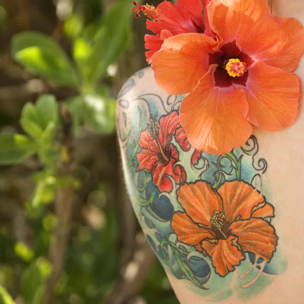 Vibrant Orange and Red Hibiscus Flowers set against a Swirling background | selftattoo.com