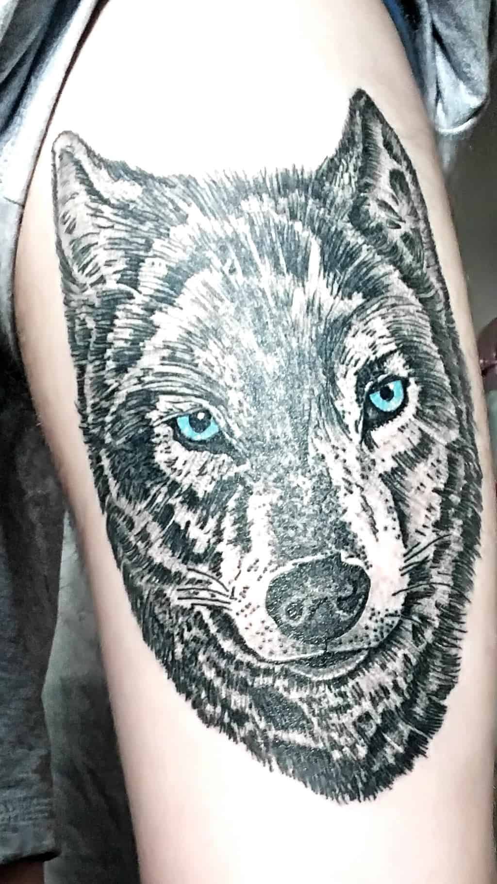 Textured Black and Gray Wolf Head with Blue Eyes Upper Arm Tattoo | selftattoo.com