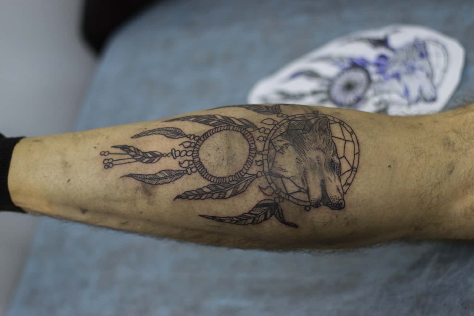 Black and Gray Dreamcatcher with a Wolf's Head at the Center of the Web Forearm Tattoo | selftattoo.com