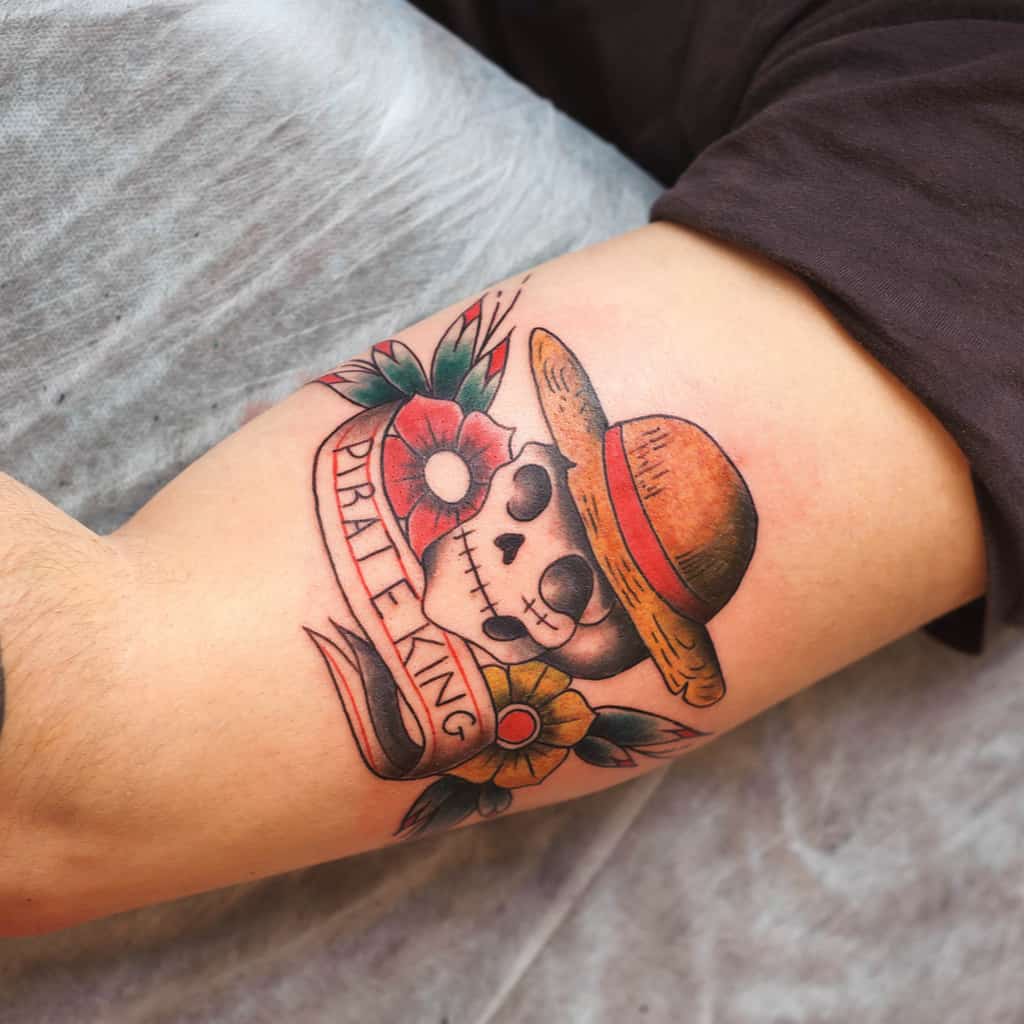 Colorful Traditional Style Skull Tattoo wearing a Straw Hat with Flowers and a "PIRATE KING" Banner | selftattoo.com