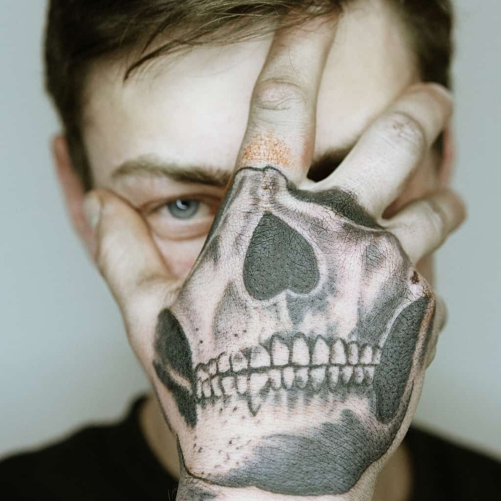 Detailed Black and Gray Jaw of a Skull Top of Hand Tattoo | selftattoo.com