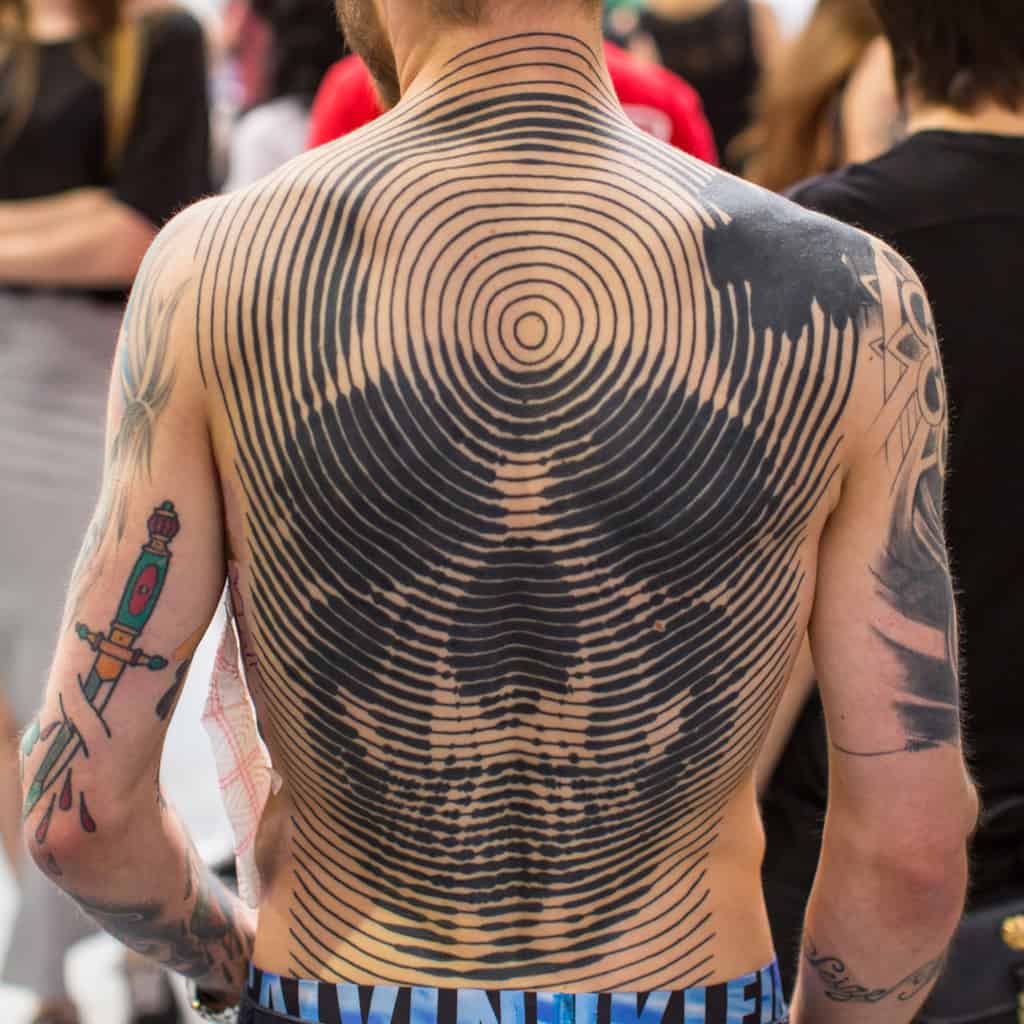 Bold Black Skull created using Circles radiating Outwards Full Back Tattoo | selftattoo.com