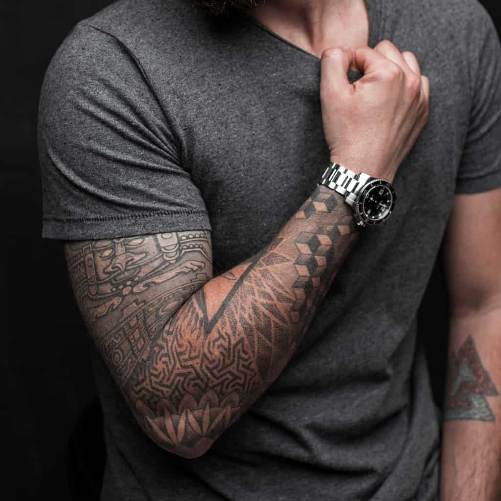 Black and Gray Geometric Forearm Tattoo with a Mix of Repeated Triangular and Square Patterns | selftattoo.com