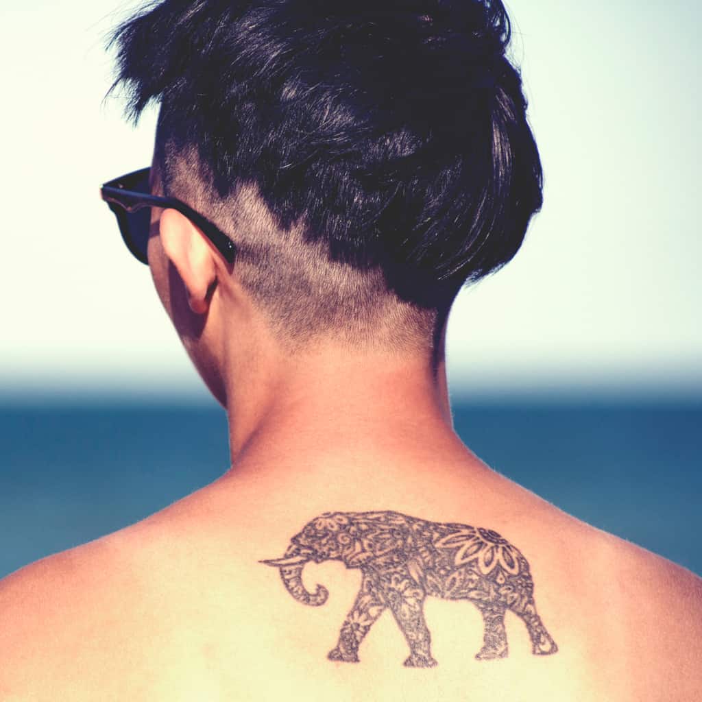 Bold and Black Silhouette of an Elephant filled with Floral and Mandala Patterns Upper Back Tattoo | selftattoo.com