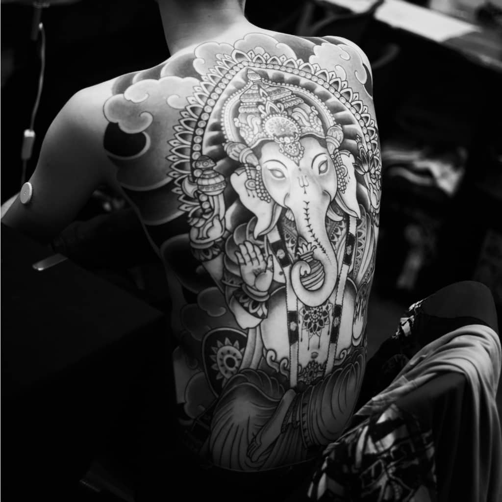 Large Decorative Black and Gray Hindu Deity Ganesha surrounded by Clouds Full Back Tattoo | selftattoo.com