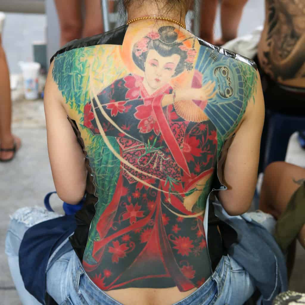 Stunning and Vibrant Full Back Tattoo of a Traditional Japanese Geisha in Shades of Red and Black | selftattoo.com