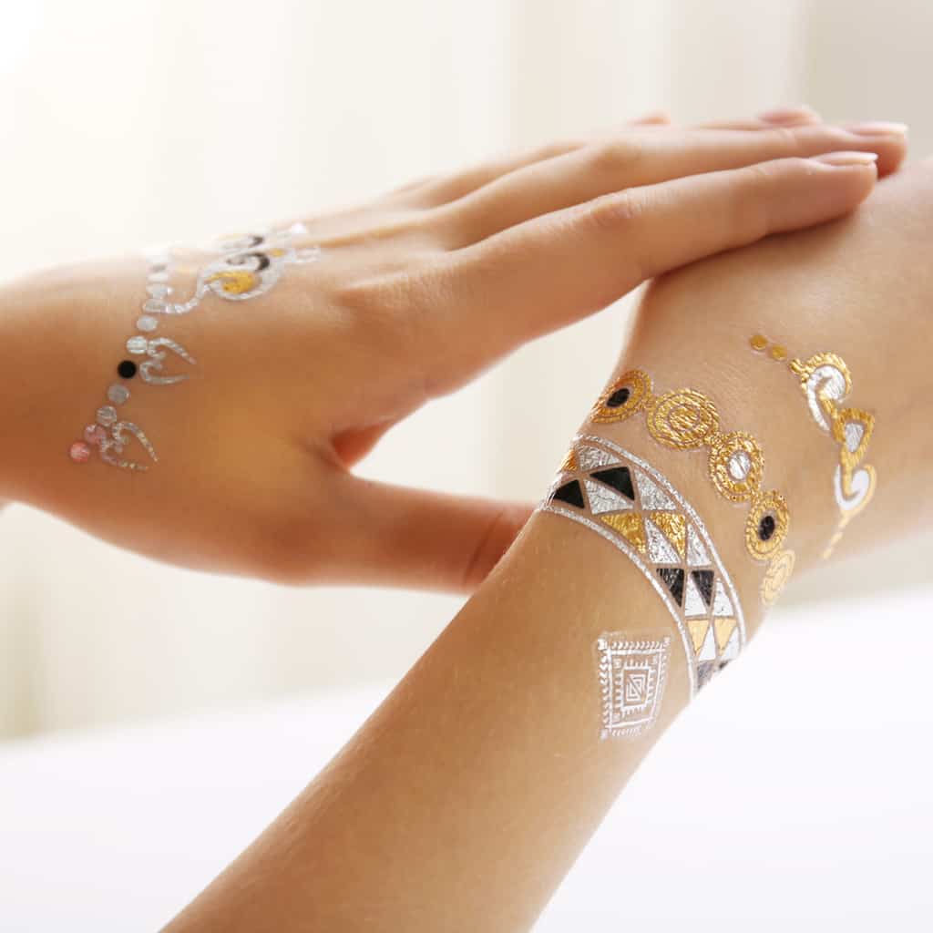 Woman's Hands Decorated with Gold Silver and Black Temporary Tattoos of Small Ornamental Shapes | selftattoo.com