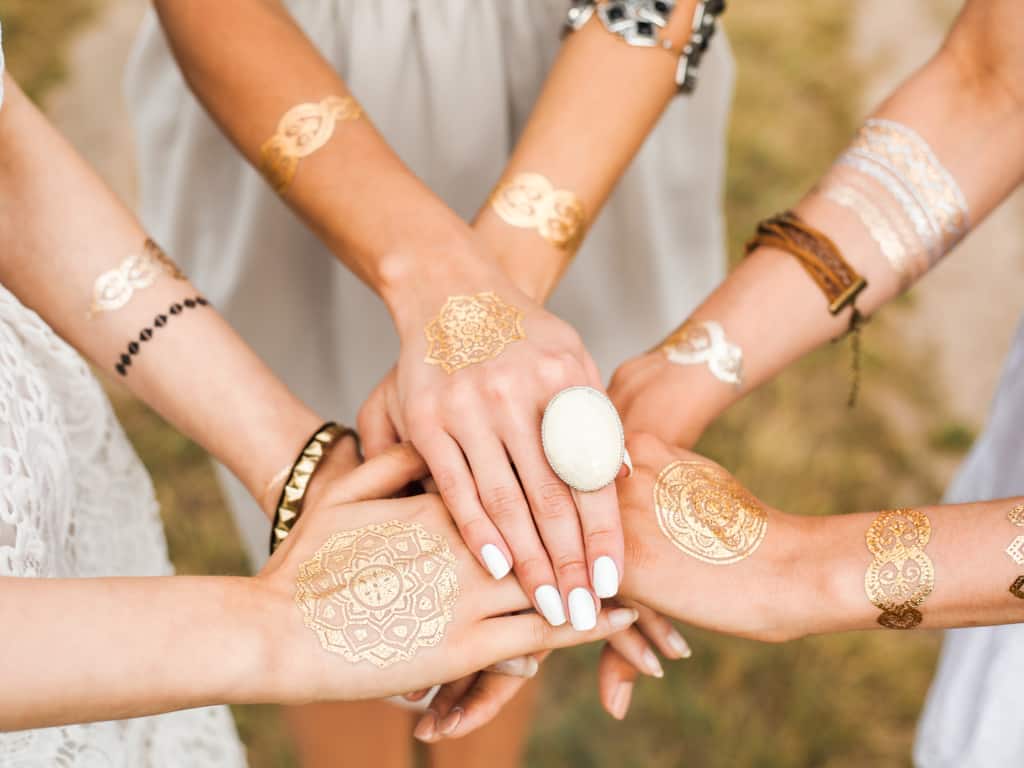 Close-up View of Six Women's Hands Stacked Together with Gold/White Temporary Mandala Tattoos | selftattoo.com