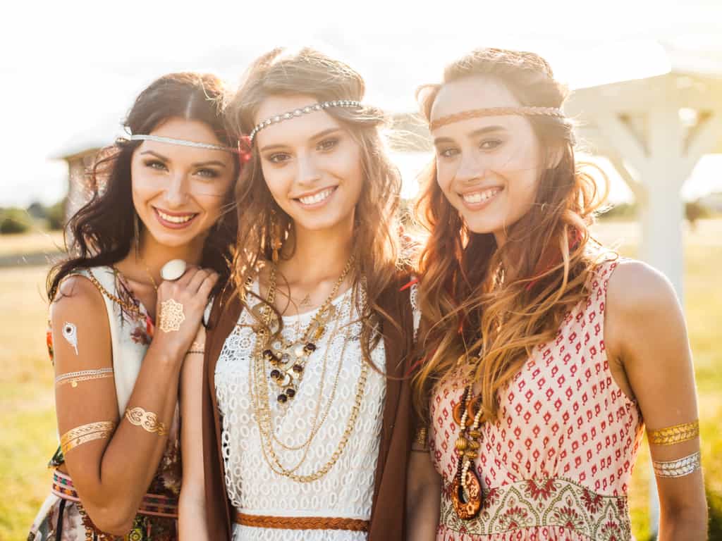 Three Young Women Standing Close Together in Bohemian Style Clothing with Temporary Tattoos | selftattoo.com