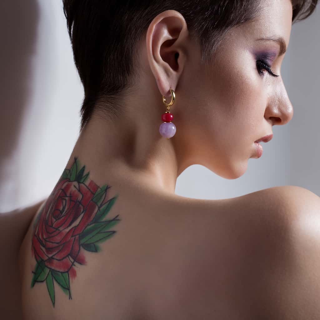 Colorful Sketch Tattoo of a Red Rose surrounded by Green Leaves Upper Back Tattoo | selftattoo.com