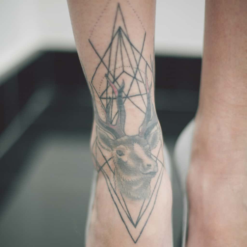 Detailed Black and Gray Deer's Head combined with Geometric lines Ankle Tattoo | selftattoo.com