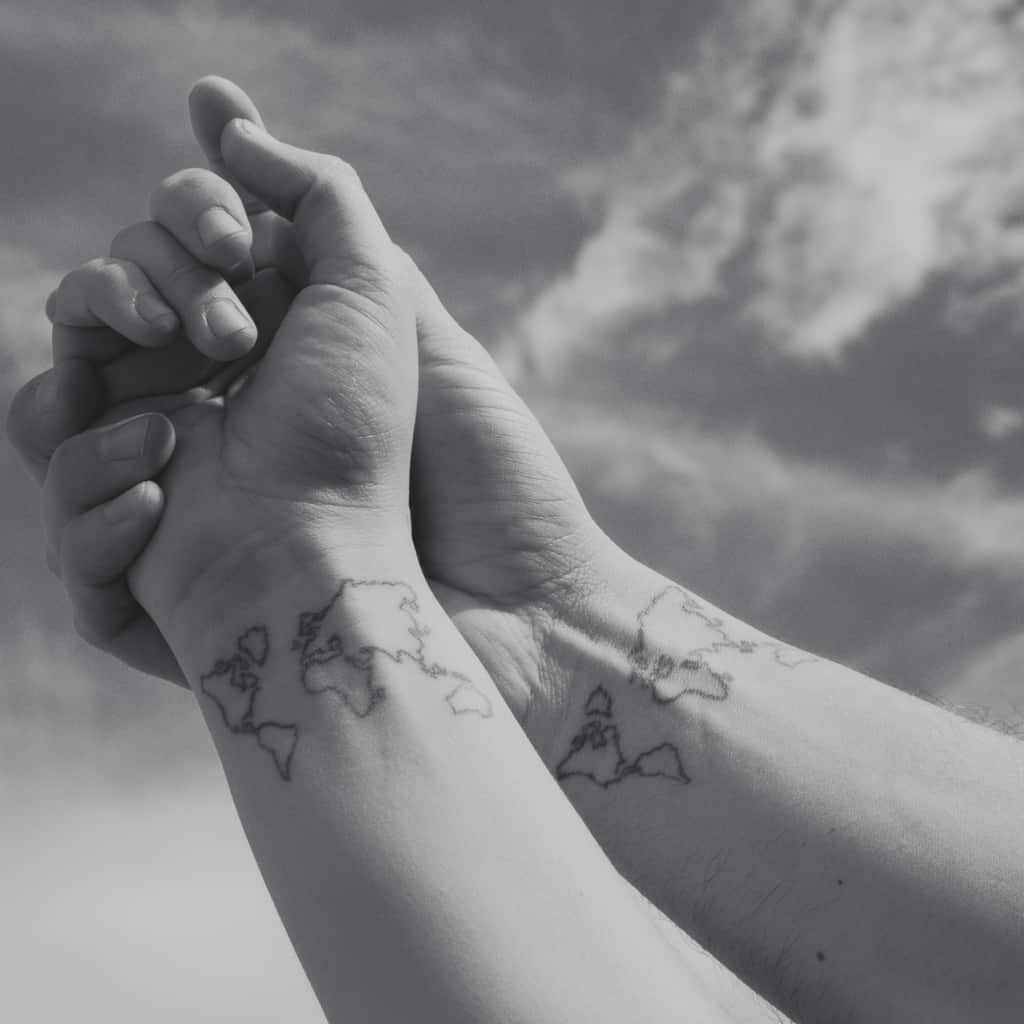 Couple with Matching Black Outline of the World Map Inner Wrist Tattoo | selftattoo.com