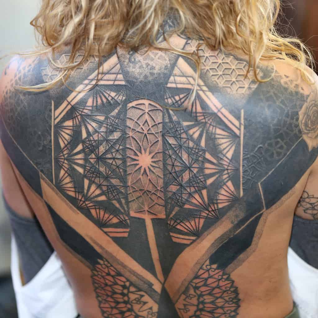 Complex Black and Gray Geometric Interlocking Patterns with Negative Space Full Back Tattoo | selftattoo.com