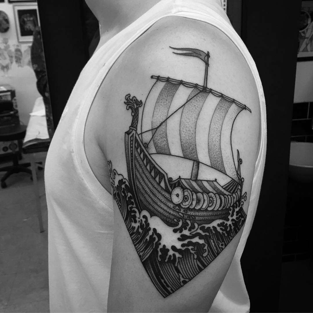 Bold Black and Gray Linework of a Viking Long Boat Upper Arm Tattoo | selftattoo.com