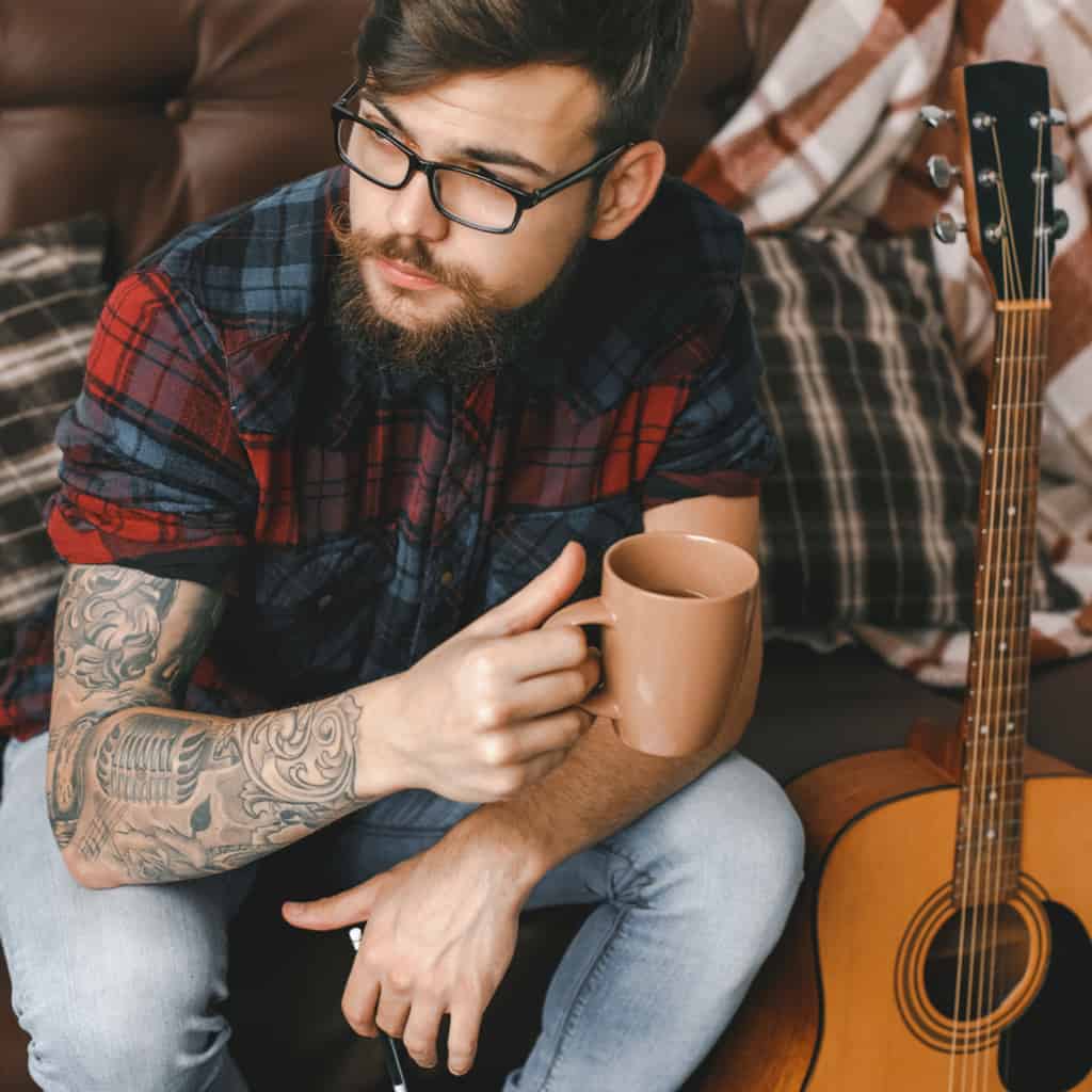 Realistic Black and Gray Vintage Style Microphone surrounded by Swirls and Floral Motifs Arm Tattoo | selftattoo.com