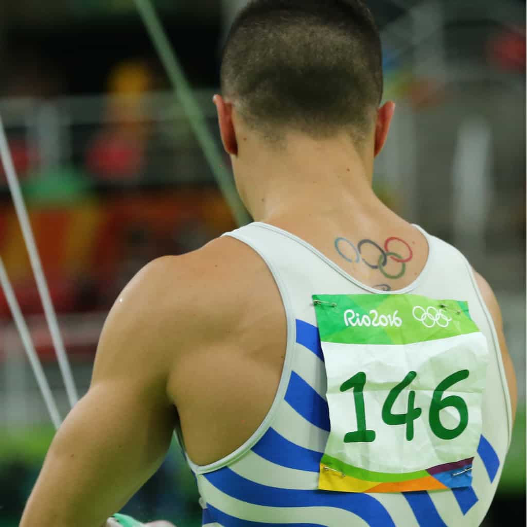 Gymnast with Five Colorful Interlocking Rings Upper Body Tattoo symbolising the Olympic Games | selftattoo.com