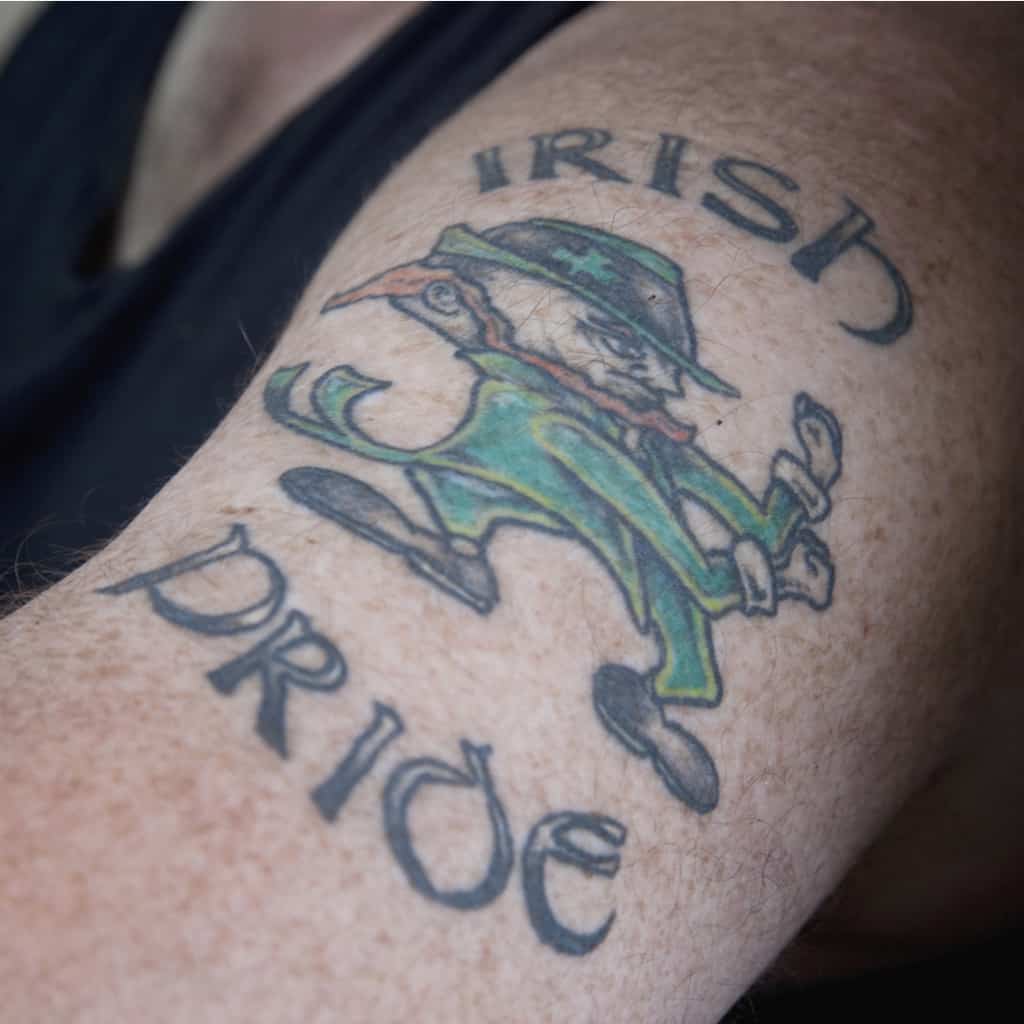 Bold and Colorful Leprechaun Tattoo surrounded with the Words "Irish Pride" | selftattoo.com