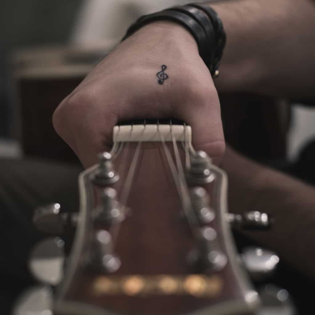 Small Black Treble Clef Symbol Hand Tattoo | selftattoo.com