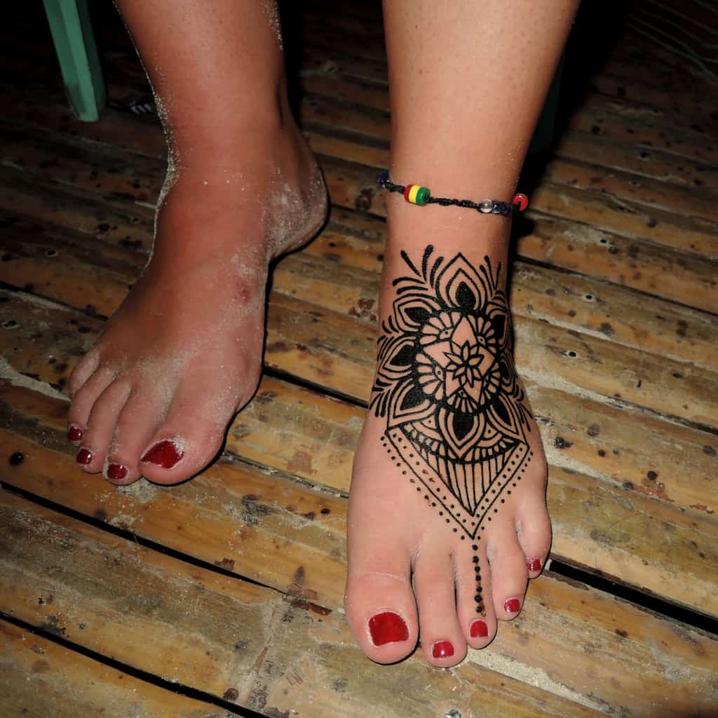 Large Bold Black Linework of a Mandala Top of Foot Jagua Tattoo | selftattoo.com