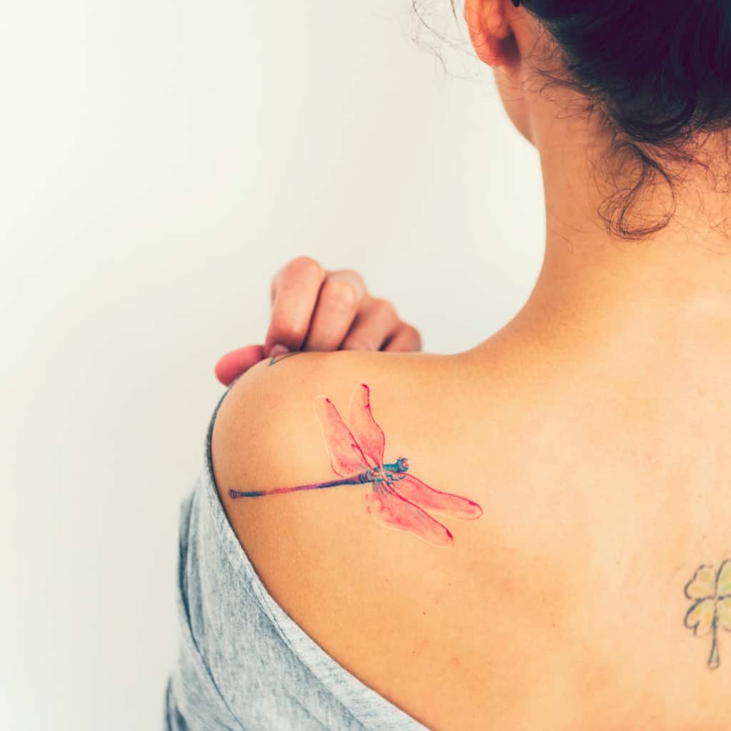 Hyper Realistic Dragonfly Shoulder Tattoo with Soft Flowing Colors in Pink and Blue | selftattoo.com