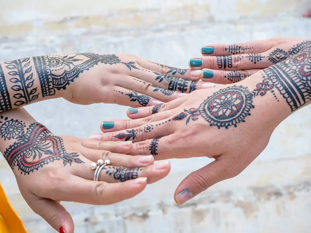 Group of Hands decorated with Jagua Tattoos resembling Traditional Henna Designs | selftattoo.com