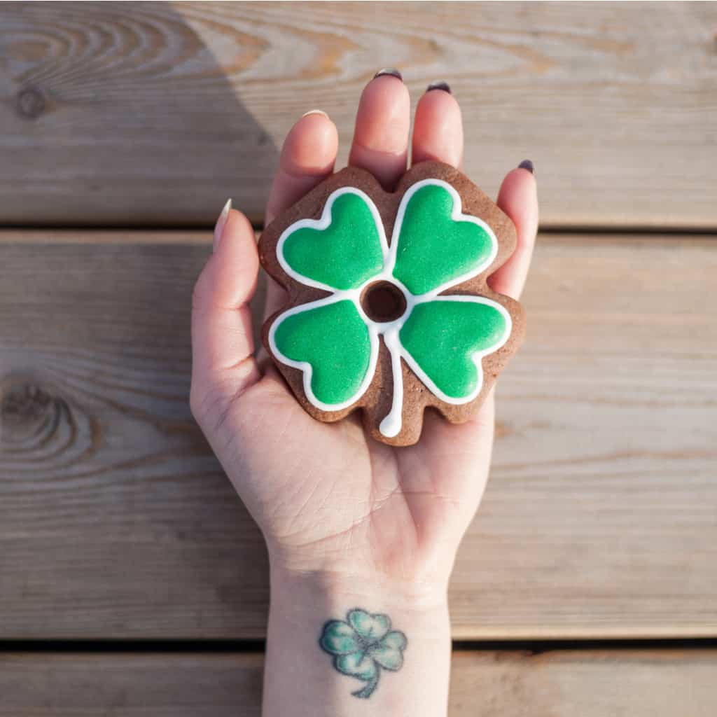 Small Simple Four Leaf Clover with Black Outlines and Soft Green Colors Wrist Tattoo | selftattoo.com