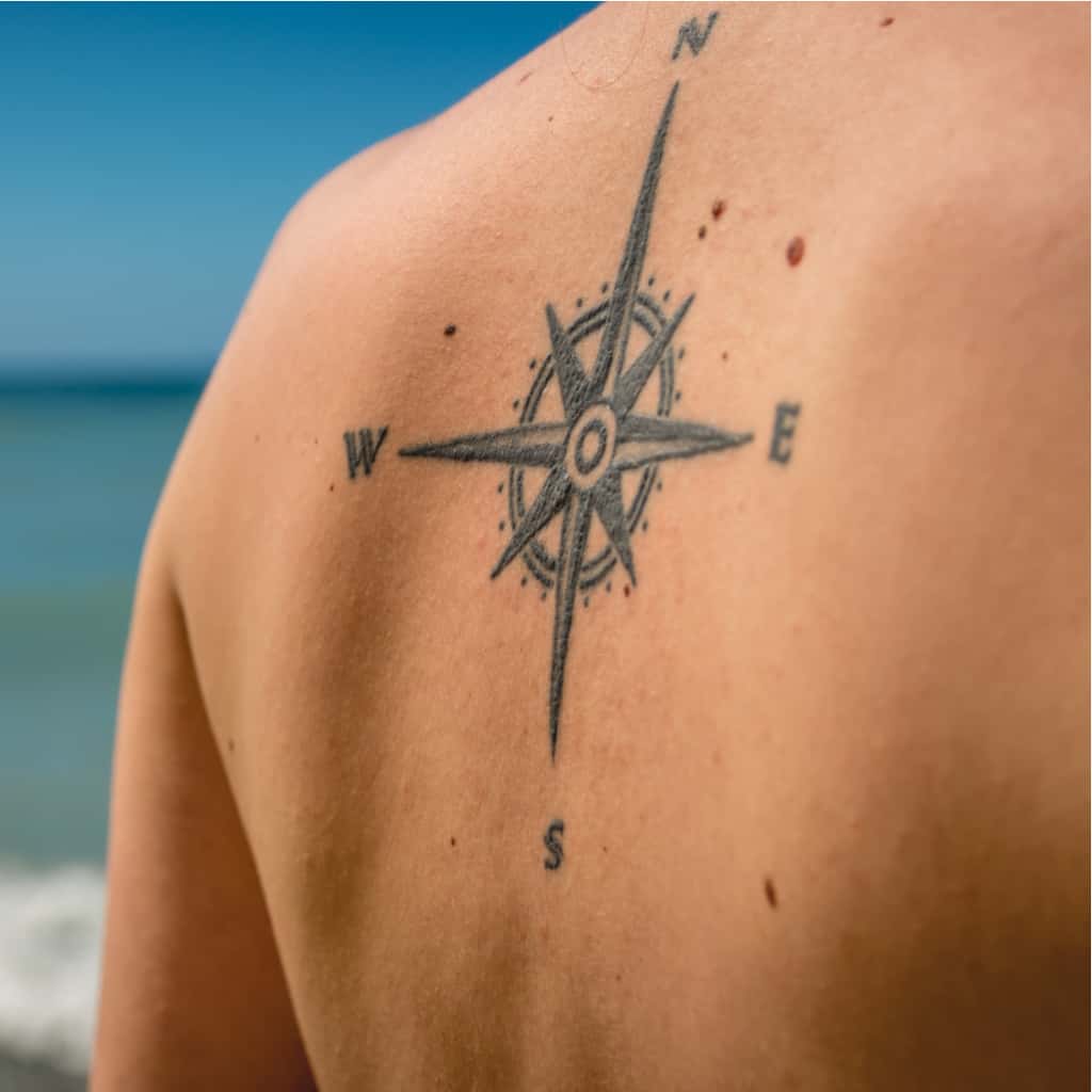 Black Compass Rose Tattoo with Long Directional Markers and "N" "S" "E" "W" Cardinal Directions | selftattoo.com