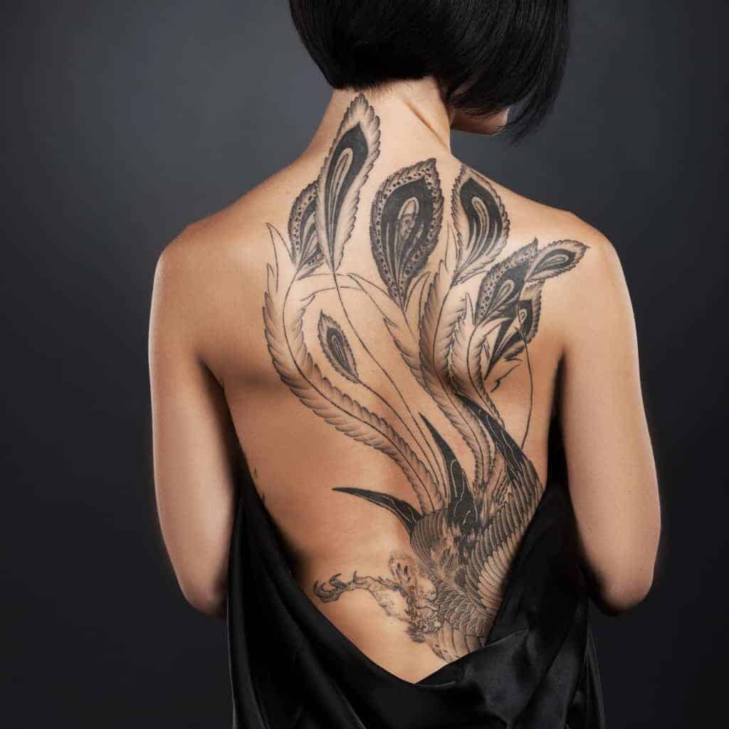 Large Black and Gray Peacock with Long Flowing Tail Feathers Full Back Tattoo | selftattoo.com