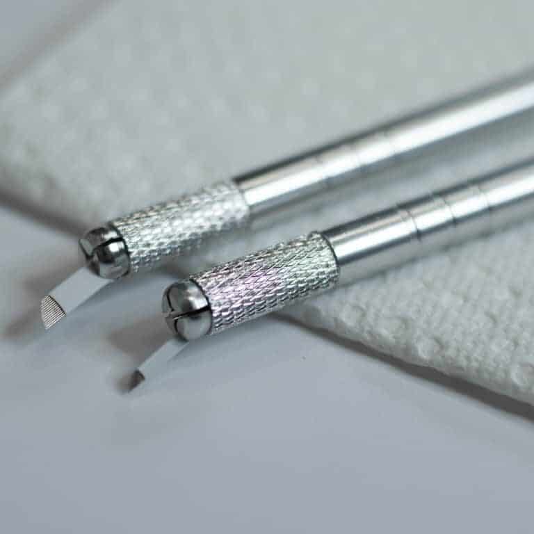 Close-up of Two Microblading Tools placed on a White Surface | selftattoo.com