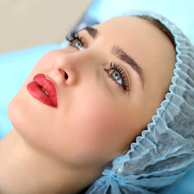 Woman laying down with Vibrant Red Lips after a Lip Blushing Procedure | selftattoo.com