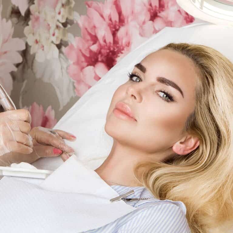 Woman laying on a bed in a Beauty Clinic after undergoing Cosmetic Enhancements | selftattoo.com