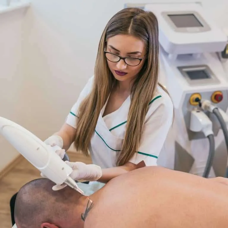 Laser Tattoo Removal Professional using a Handheld Laser Device on a Person's Neck | selftattoo.com