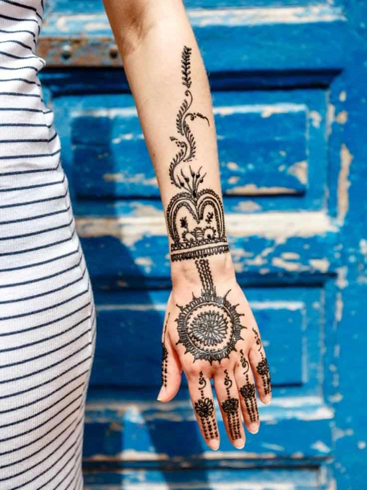 Circular Mandala Pattern surrounded by Lines of Repetitive Curves Hand and Wrist Jagua Tattoo | selftattoo.com